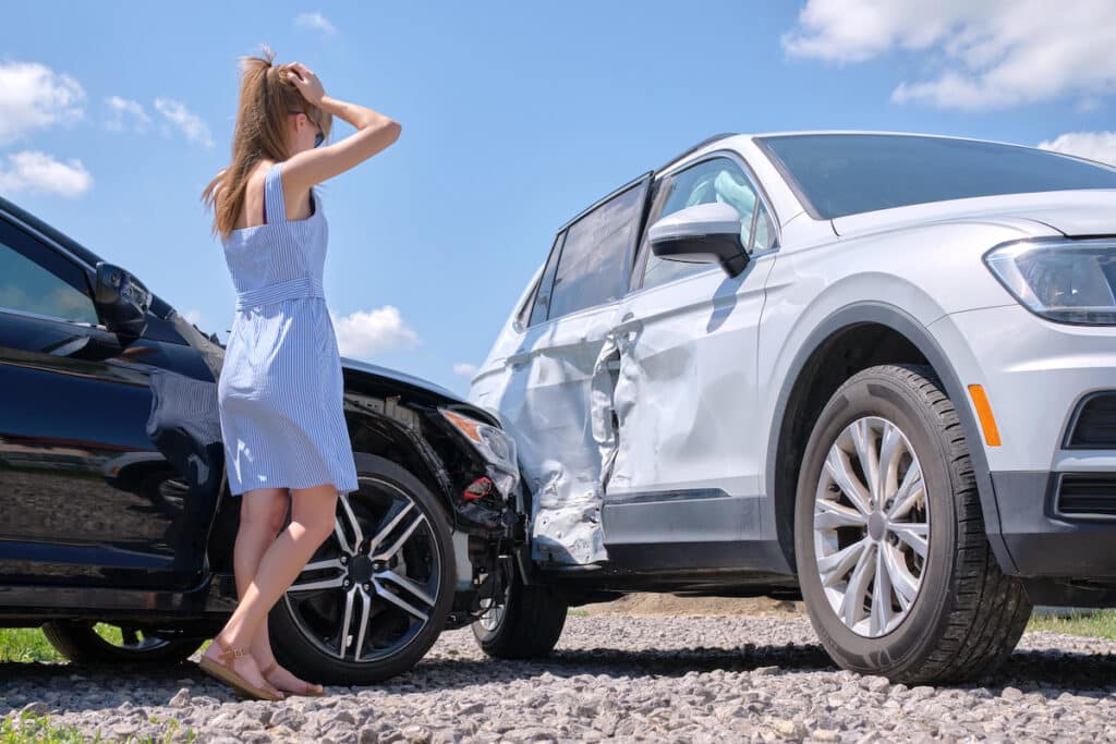 rental car accident photo - woman in dress looking at car damage